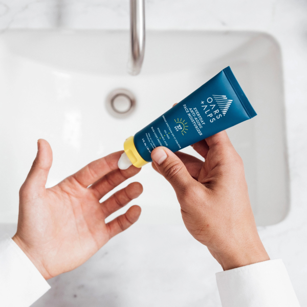 oars and alps anti aging face cream on finger