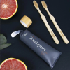 nudge toothpaste with black background and natural toothbrush